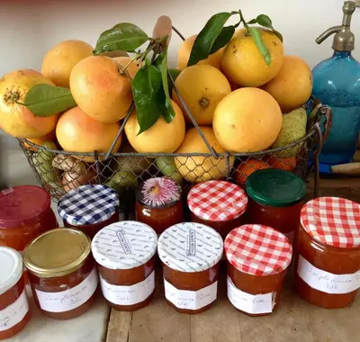 a basket of oranges and jars of jam on a table at Villa Prétorina in Cannes