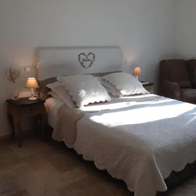 a bedroom with a white bed with two lamps and a chair at Villa Prétorina in Cannes