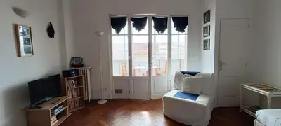 a living room with a white chair and a television at Studio Montfleury in Cannes