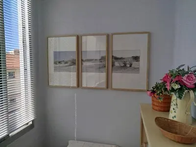 three picture frames on a wall with a vase of flowers at Studio Montfleury in Cannes