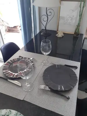 a table with a black plate and glasses on it at Grand Studio Terrasse Proche Palais des Festivals in Cannes