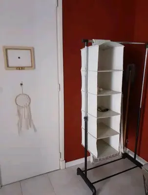 a white refrigerator in a room with a red wall at Grand Studio Terrasse Proche Palais des Festivals in Cannes