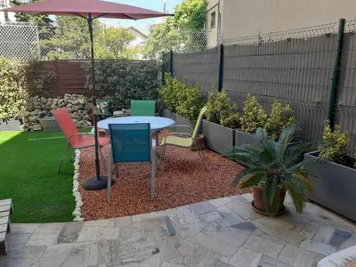 a patio with a table and chairs and an umbrella at Grand Studio Terrasse Proche Palais des Festivals in Cannes