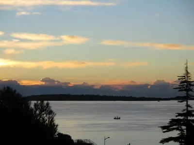 a boat on the water at sunset at Beau 2 pièces 3 étoiles Vue Mer Garage Privé 150m plages wifi in Cannes