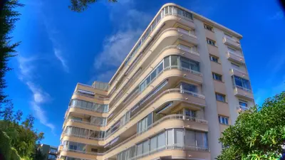 a tall white building with a blue sky in the background at Beau 2 pièces 3 étoiles Vue Mer Garage Privé 150m plages wifi in Cannes