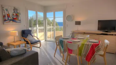 a living room with a table with chairs and a television at Beau 2 pièces 3 étoiles Vue Mer Garage Privé 150m plages wifi in Cannes