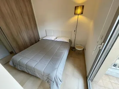 a small bedroom with a bed and a lamp at Appartements Villa Rimbaud by Connexion in Cannes
