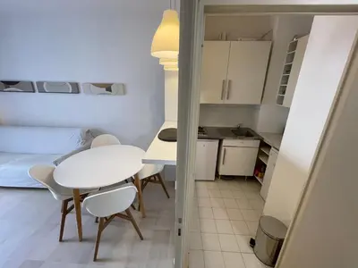 a small kitchen and a white table and chairs in a room at Appartements Villa Rimbaud by Connexion in Cannes
