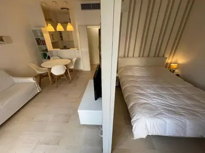 a small bedroom with a bed and a table at Appartements Villa Rimbaud by Connexion in Cannes