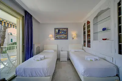 two beds in a room with a balcony at IMMOGROOM- Huge Terrace - Panoramic Sea View - 1min from Beach in Cannes