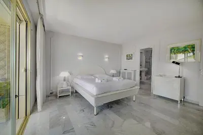 a white bedroom with a bed and two lamps at IMMOGROOM- Huge Terrace - Panoramic Sea View - 1min from Beach in Cannes