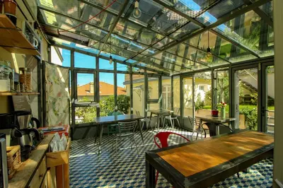 a conservatory with a table and chairs and windows at B&B Villa Du Roc Fleuri in Cannes