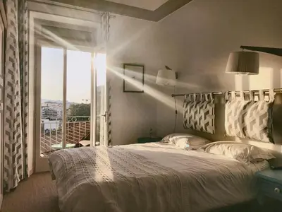 a bedroom with a large bed and a large window at B&B Villa Du Roc Fleuri in Cannes