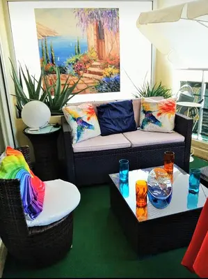 a living room with a black couch with colorful pillows at lovely apartments with terrace in Cannes
