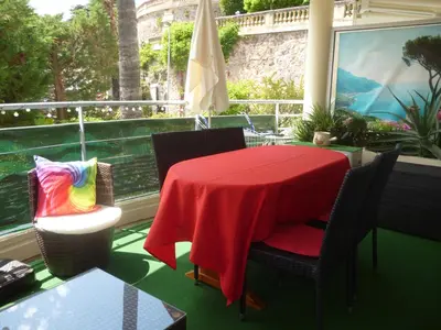 a bed with a red and black blanket on it at lovely apartments with terrace in Cannes