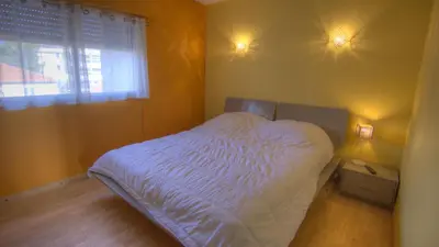 a bedroom with a bed with white sheets and a window at 3 pièces 4 étoiles Vue Mer Parking Fibre 500m Palais Festivals in Cannes