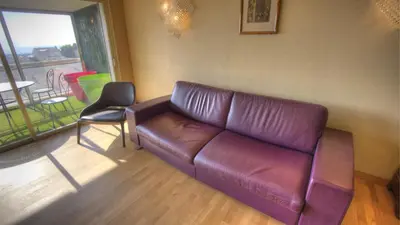a living room with a leather couch and a chair at 3 pièces 4 étoiles Vue Mer Parking Fibre 500m Palais Festivals in Cannes