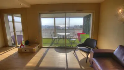 a living room with a table and chairs and a large window at 3 pièces 4 étoiles Vue Mer Parking Fibre 500m Palais Festivals in Cannes
