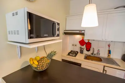 a kitchen with a microwave and a bowl of fruit on a table at Appartement et Parking Cannes Center by Connexion in Cannes
