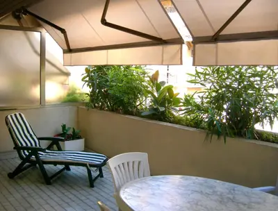 a patio with a table and two chairs and an umbrella at Appartement et Parking Cannes Center by Connexion in Cannes