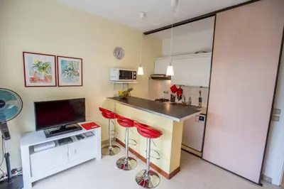 a kitchen with a counter and two red stools at Appartement et Parking Cannes Center by Connexion in Cannes