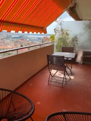 a table and chairs on a balcony with a view at Le Suquetan in Cannes