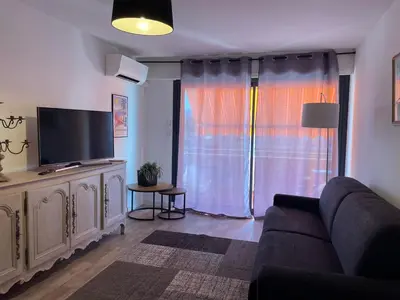 a living room with a couch and a flat screen tv at Le Suquetan in Cannes