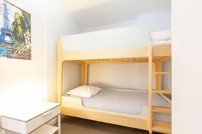 a bunk bed in a room with a desk at Modern apartment 2 bedrooms1 bathroom quiet terrace in a palm beach area in Cannes