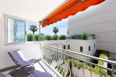 a balcony with a chair and a window at Modern apartment 2 bedrooms1 bathroom quiet terrace in a palm beach area in Cannes