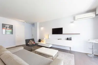 a white living room with a couch and a table at Modern apartment 2 bedrooms1 bathroom quiet terrace in a palm beach area in Cannes