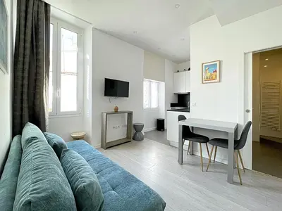 a living room with a blue couch and a table at Lovely and Modern 1 Bedroom City Centre Cannes in Cannes
