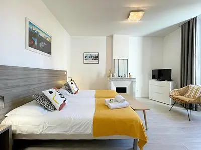 a bedroom with a bed and a tv and a chair at Lovely and Modern 1 Bedroom City Centre Cannes in Cannes