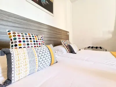a bedroom with two beds with colorful pillows at Lovely and Modern 1 Bedroom City Centre Cannes in Cannes