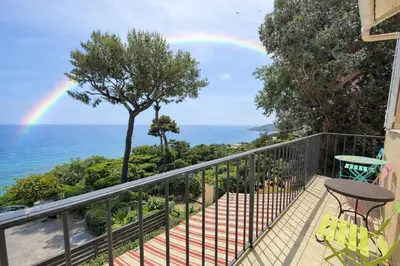 a rainbow over the ocean from a balcony at Villa Cannes I Deluxe Seafront - Sea View - Garden & Terrace -Prime Location- in Cannes