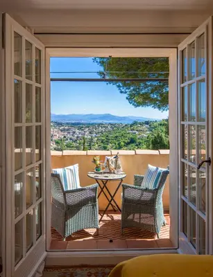 a room with a balcony with a table and chairs at Villa Le Port d'attache in Vallauris
