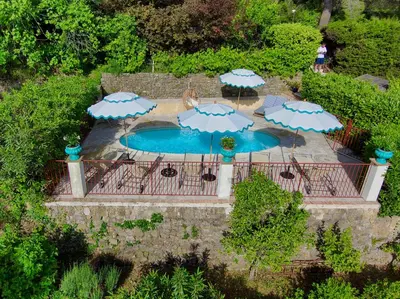 an overhead view of a pool with umbrellas and chairs at Villa Le Port d'attache in Vallauris