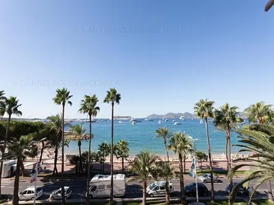 a view of a beach with palm trees and the ocean at Ô Béatrice Croisette in Cannes