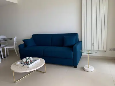a blue couch in a living room with a table at Ô Béatrice Croisette in Cannes