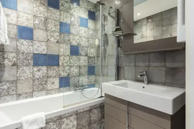 a bathroom with a sink and a mirror and a tub at Florella Antibes Apartment in Cannes