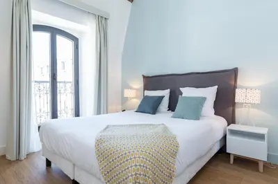 a bedroom with a large white bed with blue pillows at Florella Antibes Apartment in Cannes