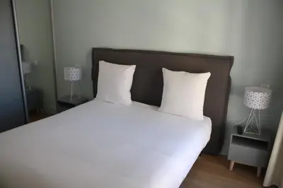 a bed with white sheets and pillows in a bedroom at Florella Antibes Apartment in Cannes