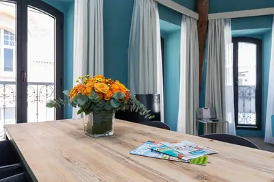 a vase of orange flowers sitting on a wooden table at Florella Antibes Apartment in Cannes