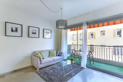 a living room with a couch and a balcony at Studio Cosy Merle in Cannes