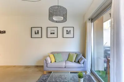 a living room with a couch and a pendant light at Studio Cosy Merle in Cannes