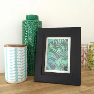 a picture frame next to a vase and a bottle at Studio Cosy Merle in Cannes