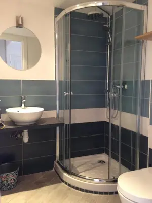 a bathroom with a glass shower and a sink at Suquet Charm in Cannes