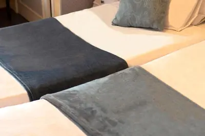 a bedroom with a large white bed with pink curtains at Hôtel Bellevue Cannes in Cannes