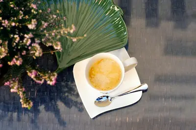 a cup of coffee on a plate with a spoon at Hôtel Bellevue Cannes in Cannes