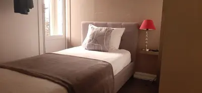a bedroom with a bed with a lamp and a window at Hôtel Bellevue Cannes in Cannes