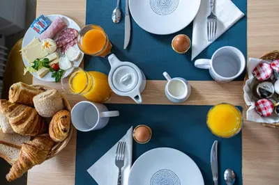 a table with plates of breakfast foods and orange juice at Hotel Albert 1er in Cannes